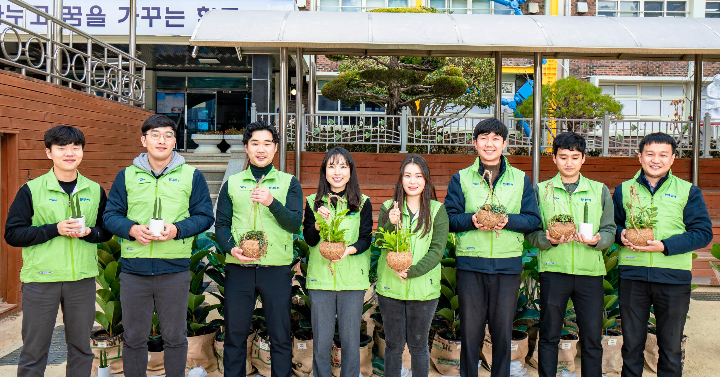현대위아 직원들이 19일 ‘현대위아 초록학교’로 꼽힌 경상남도 창원시 남양초등학교에서 교실숲을 만들 화분을 들고 기념사진을 찍고 있다.