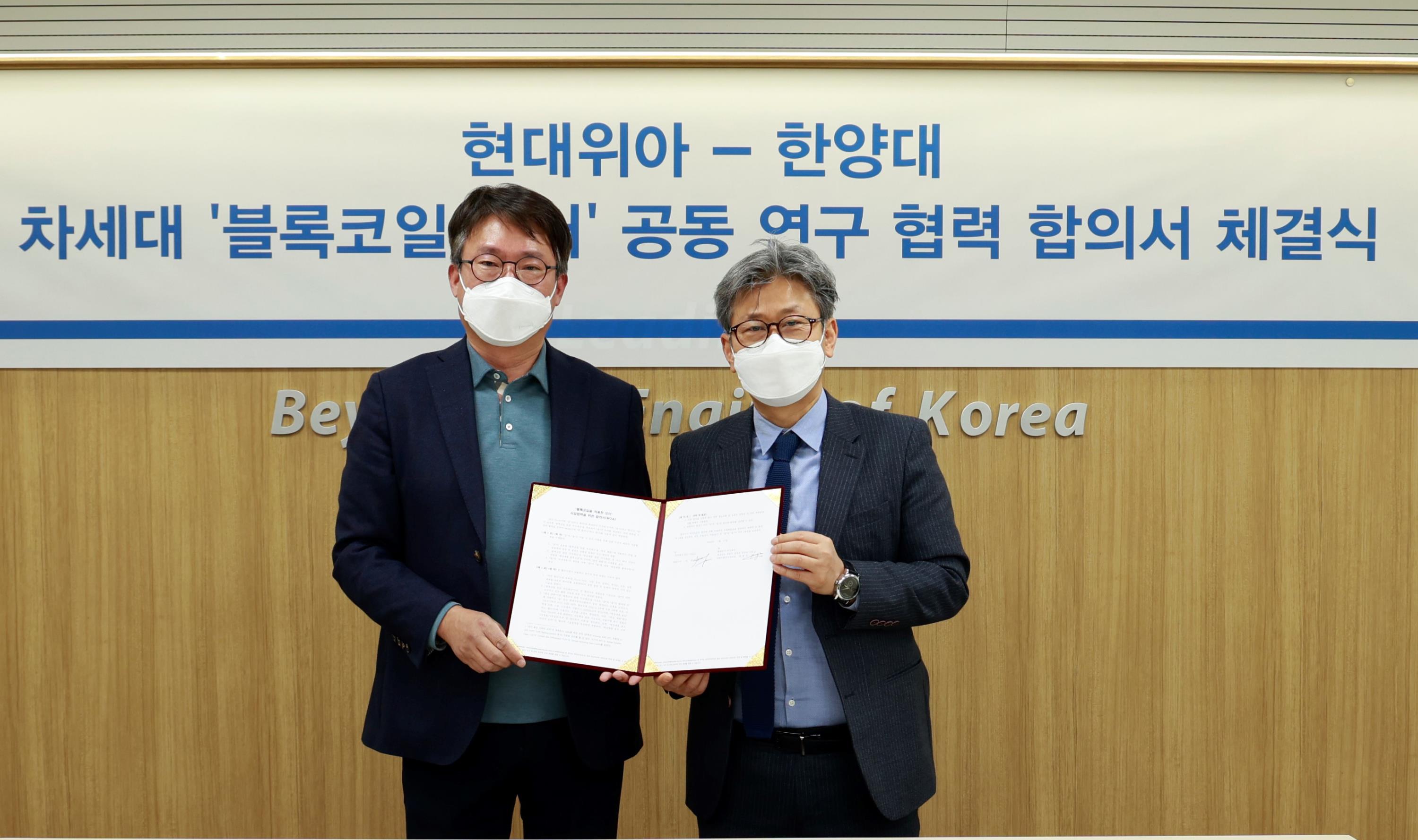 현대위아 차량부품연구센터장 원광민 상무(왼쪽)와 한양대 이주 교수가 22일 서울 성동구 한양대학교에서 '블록코일을 적용한 모터 사업 협력을 위한 합의서(MOA)'를 체결하고 기념 사진을 찍고 있다.