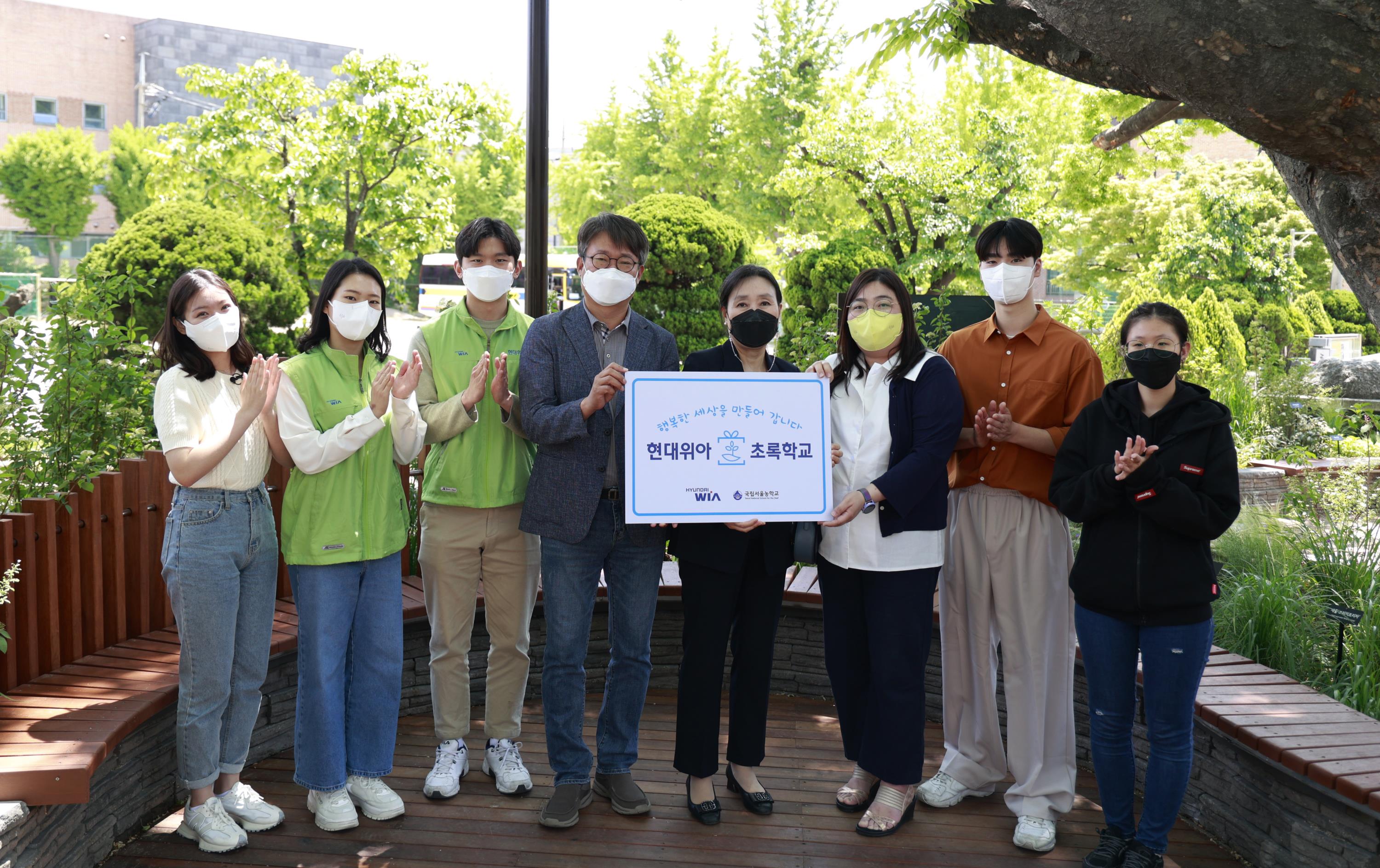 현대위아 임직원들과 국립서울농학교 학생 및 교사들이 지난 10일 서울 종로구 국립서울농학교 내 현대위아가 조성한 ‘느티나무 정원’에서 기념사진을 찍고 있다.