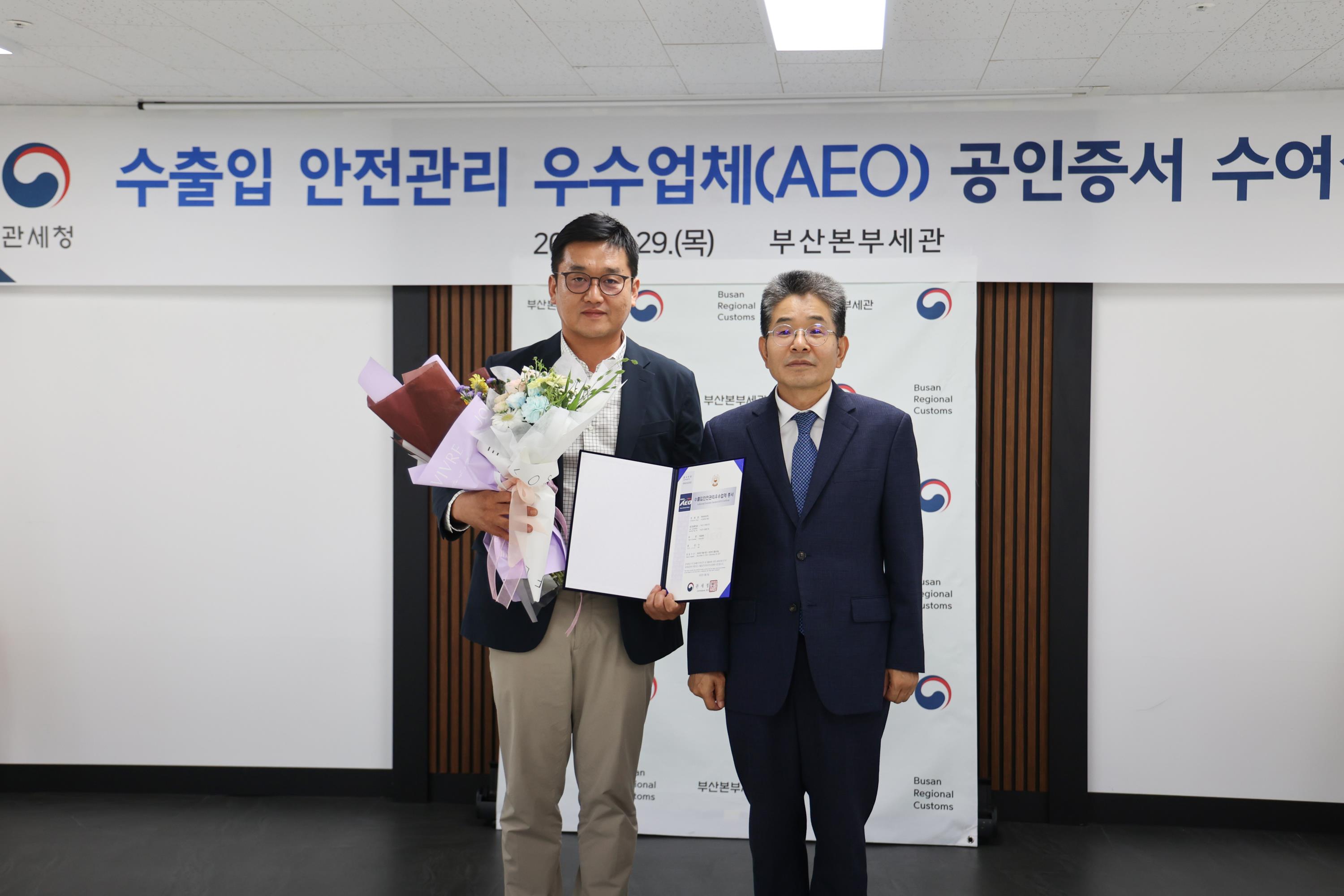 현대위아 구매전략실 임상현 실장(왼쪽)이 지난 29일 부산광역시 중구 부산본부세관에서 수출입안전관리우수업체(AEO) ‘AA’등급 인증서를 받은 후 김용식 부산본부세관장과 함께 기념사진을 찍고 있다.