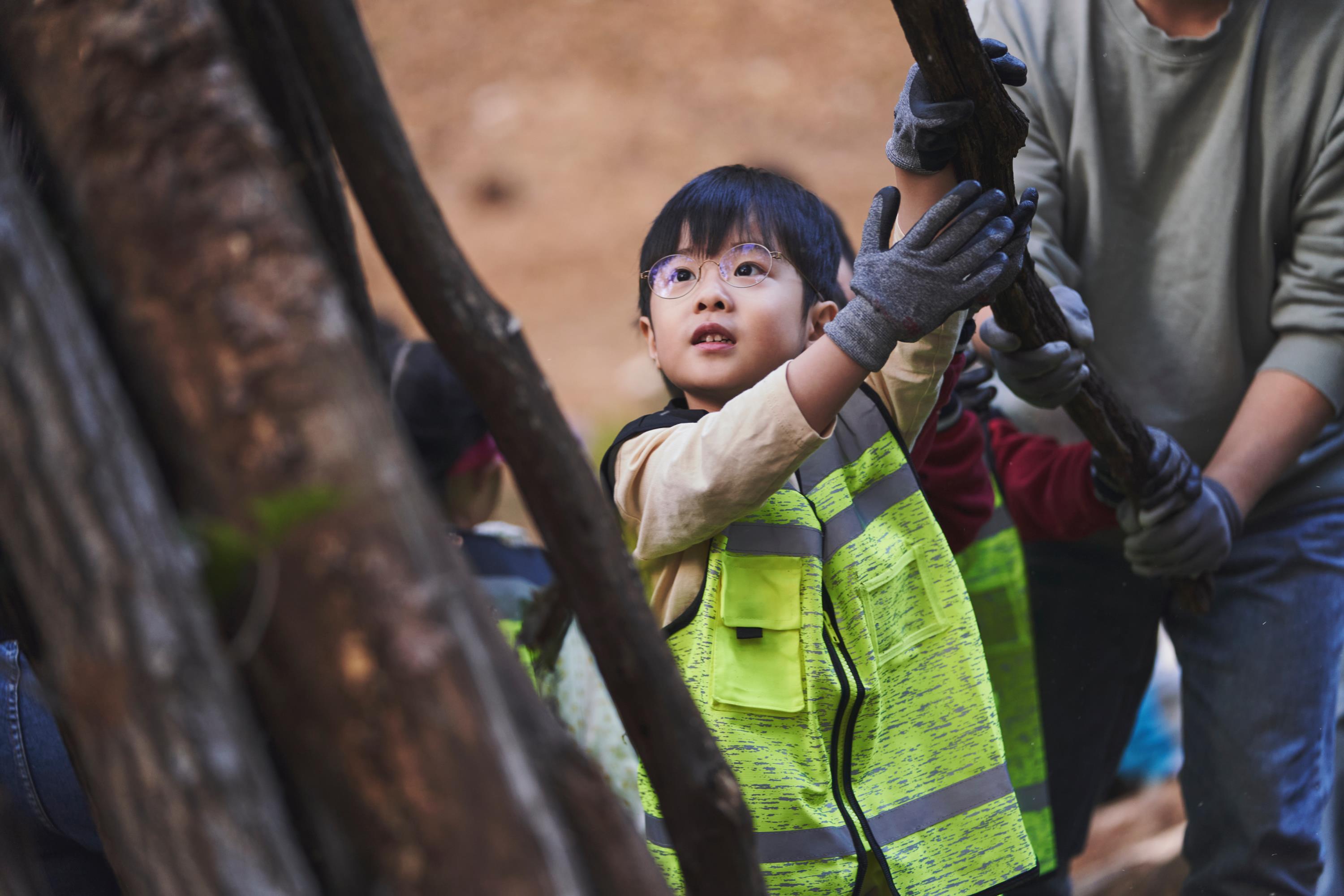 현대위아 임직원 가족이 지난 1일 경기도 이천시 포레스트벤처스 식물연구센터 생태숲에서 나뭇가지를 옮기며 고라니 쉼터를 만드는 모습.