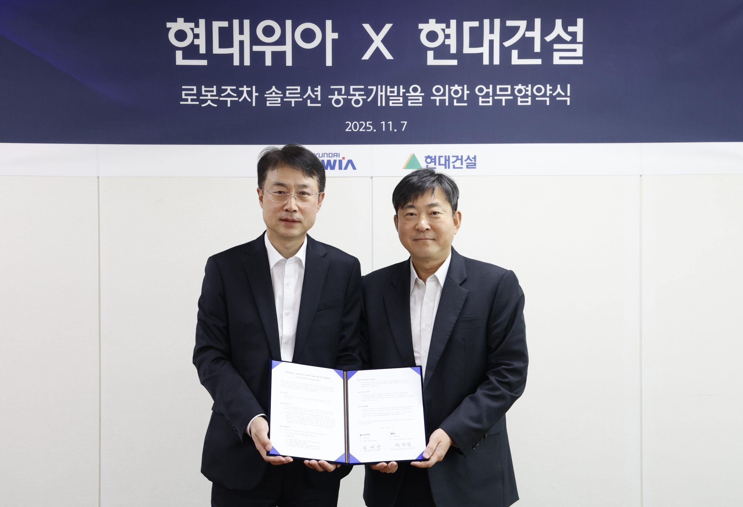 현대위아 모빌리티솔루션사업부 백익진 상무(왼쪽)와 현대건설 기술연구원 김재영 원장이 7일 경기도 의왕시 현대위아 의왕연구소에서 열린 ‘로봇 친화형 주차솔루션 공동개발을 위한 업무협약식’에서 기념 사진을 찍고 있다.