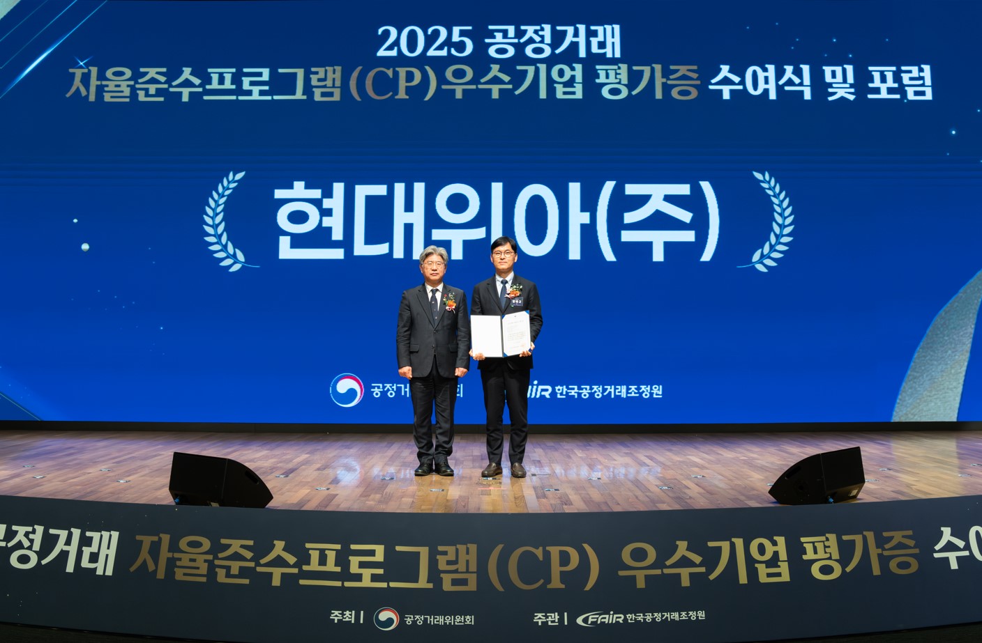 현대위아 경영지원본부장 양태규 전무(오른쪽)가 공정거래위원회 남동일 부위원장과 지난 19일 서울시 중구 대한상공회의소에서 열린 공정거래위원회의 ‘2025년 하반기 CP 포럼 및 평가증 수여식’에서 기념사진을 찍고 있다.