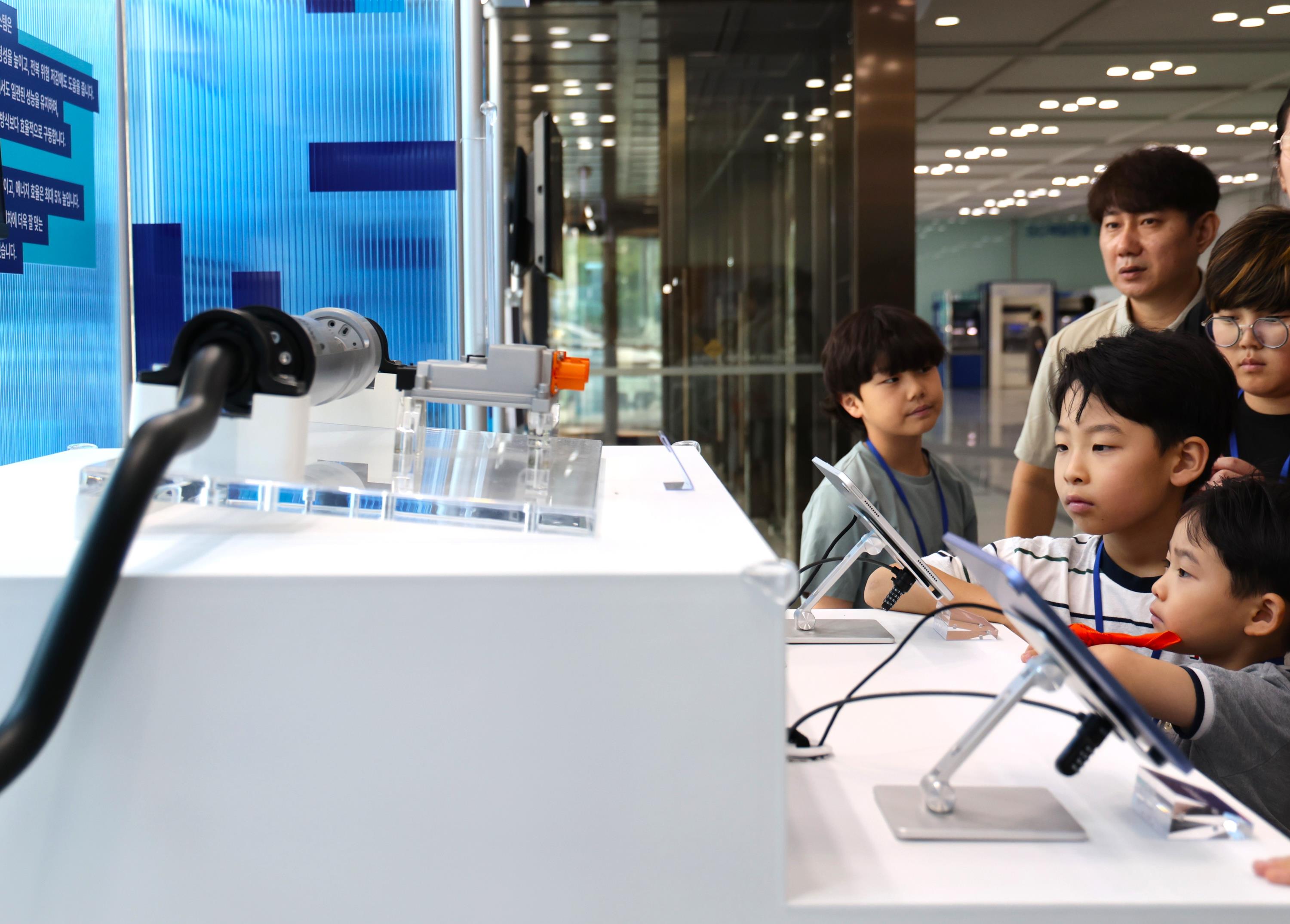지난 25일 경기도 의왕시 현대위아 의왕연구소에서 열린 '오픈 랩(Open LAB)' 행사에 참여한 임직원과 가족들이 현대위아의 ARS(Active Roll Stabilization) 전시품을 살펴보는 모습.